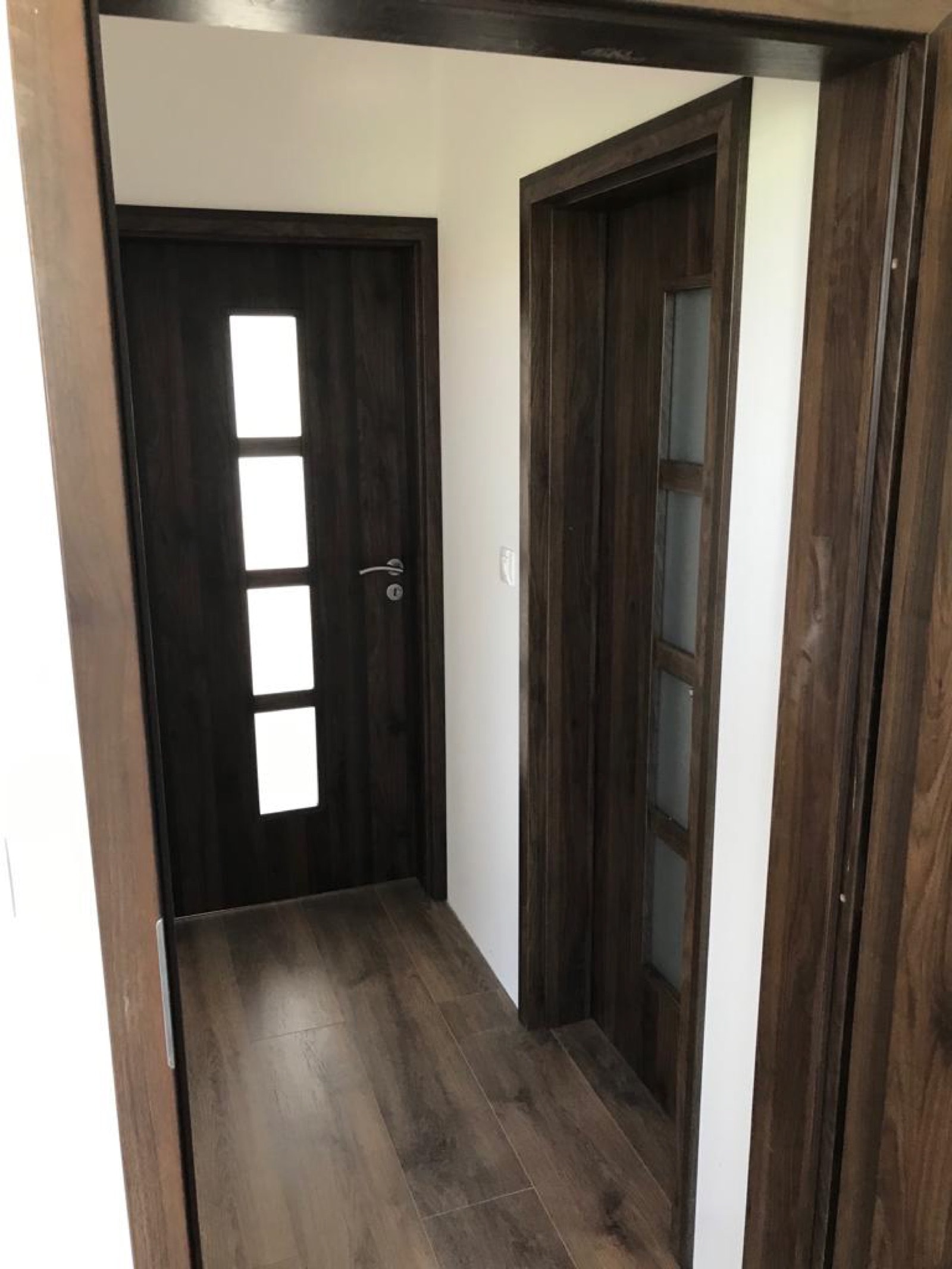 Detail osadenia interiérových dverí v dekore tmavého dreva s presklením v rodinnom dome, Šaľa — DrevoAnt.